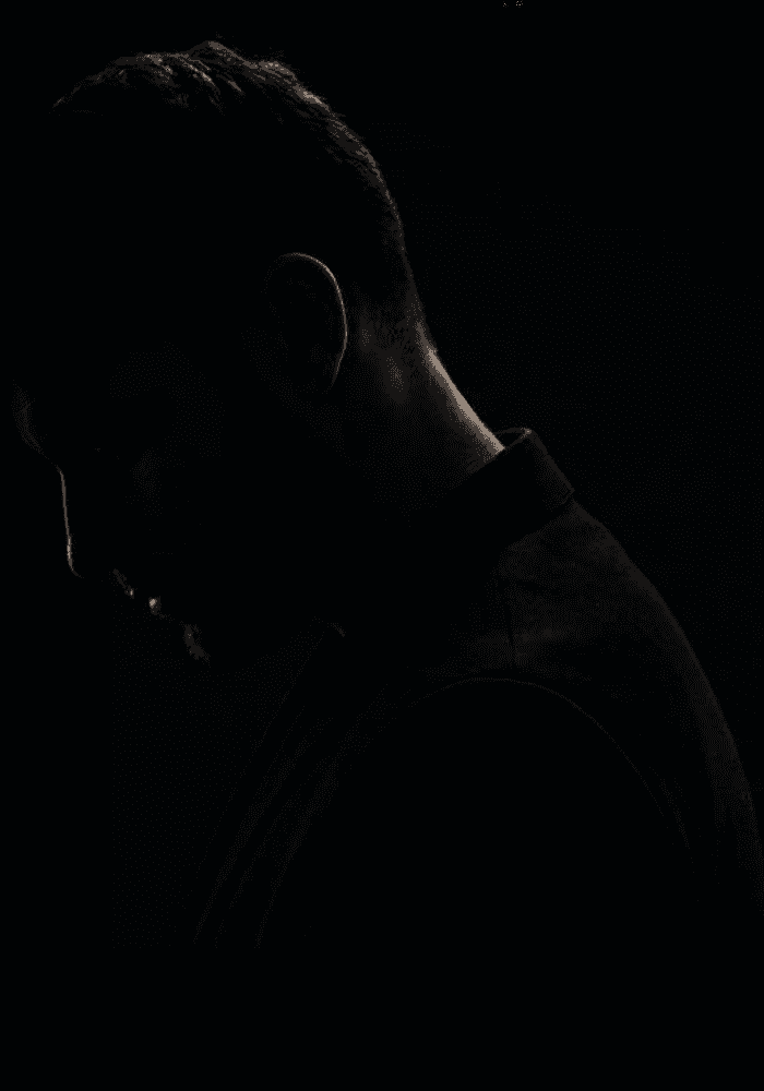 Side profile of a model in a dark collared shirt
